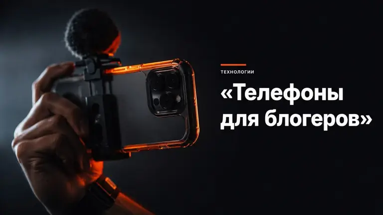 Смартфон в руке снимает видео в тёмной студийной подсветке с оранжевым акцентом